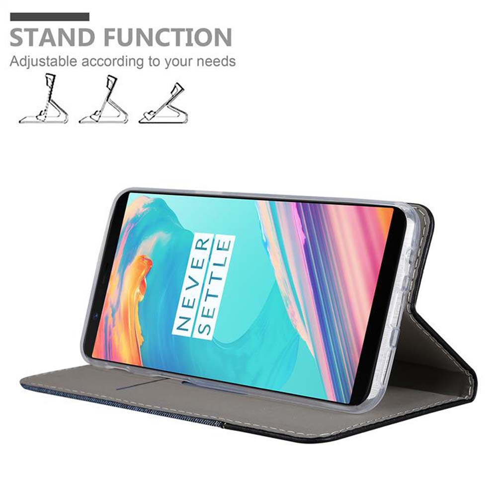 Ein Telefon in einer Hülle, hochgestellt. Der Bildschirm zeigt ein Bild an. Die Hülle ist offen. Auf dem Tisch.