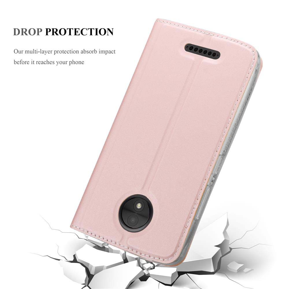 Custodia rosa per telefono, chiusa, su cemento rotto. Etichetta di protezione dalle cadute in alto a sinistra.