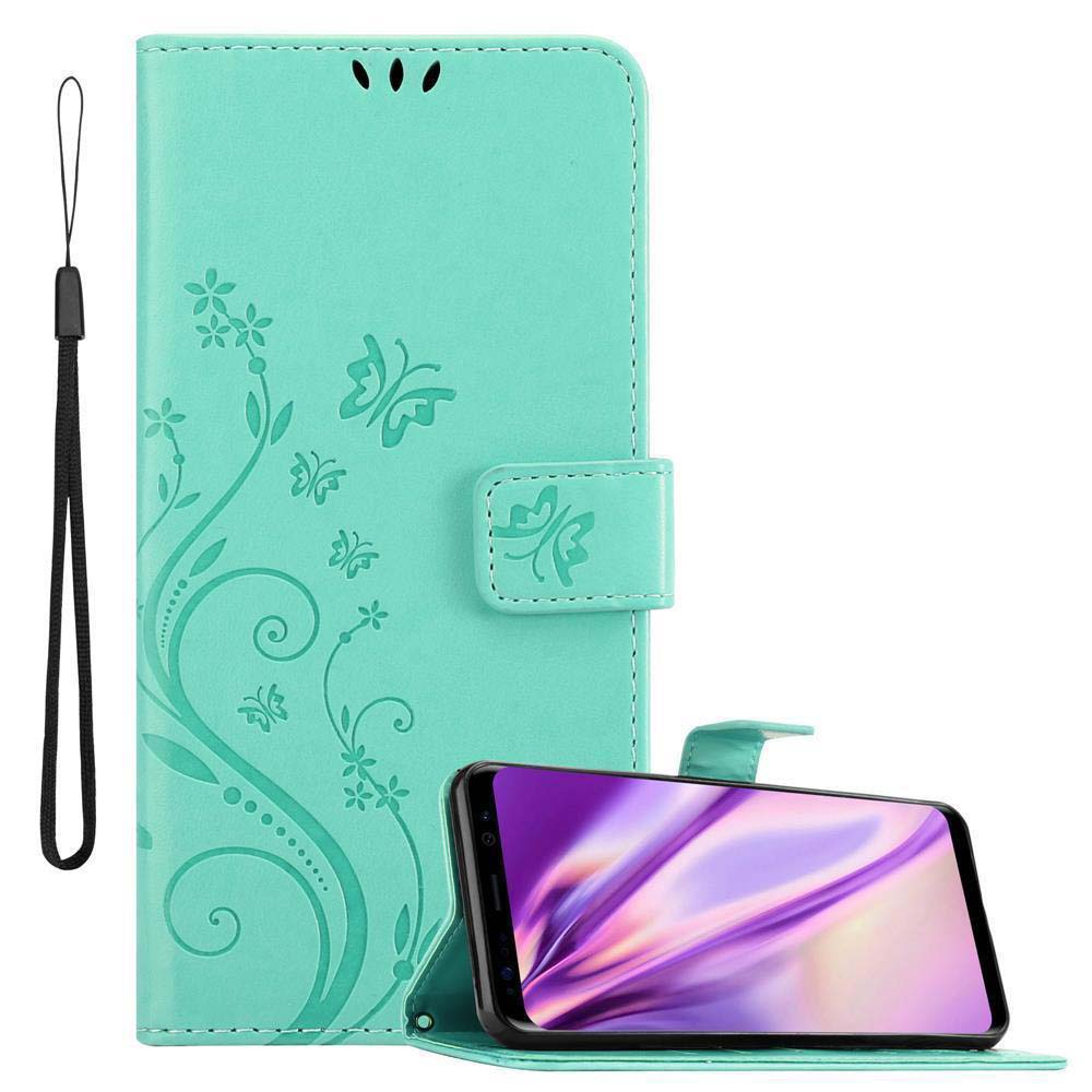 Custodia verde acqua con un telefono all'interno, su sfondo bianco. Con decorazioni floreali e farfalle.