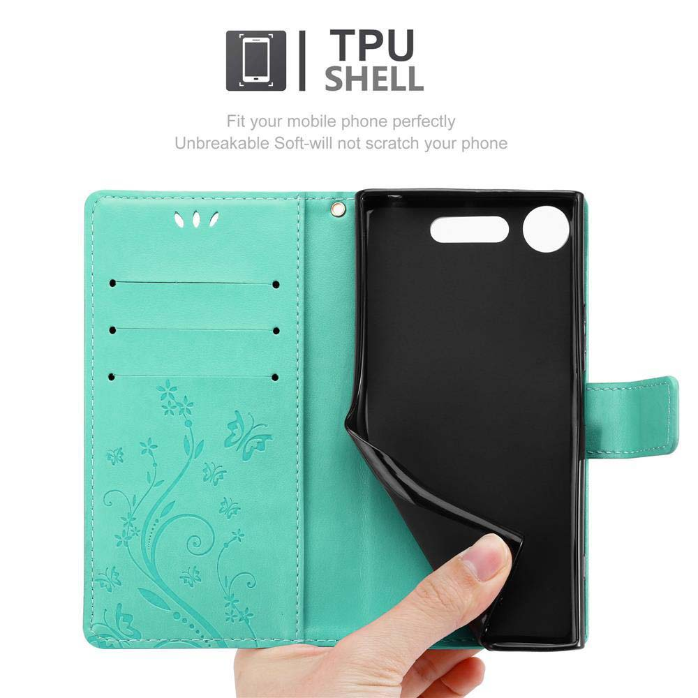 Telefono in una custodia verde, che mostra un disegno floreale, con una mano.