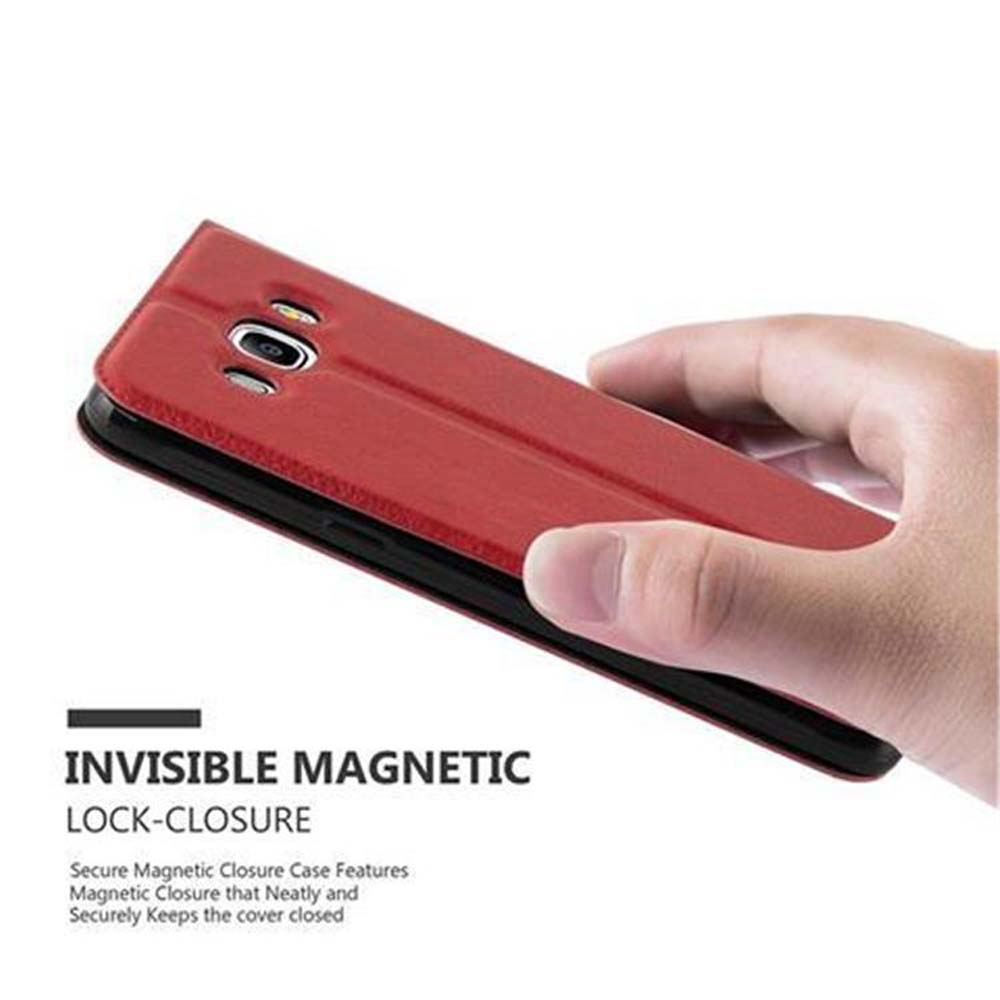 Una custodia rossa per telefono, tenuta aperta. Una mano tiene la custodia. La custodia è progettata per chiudersi magneticamente.