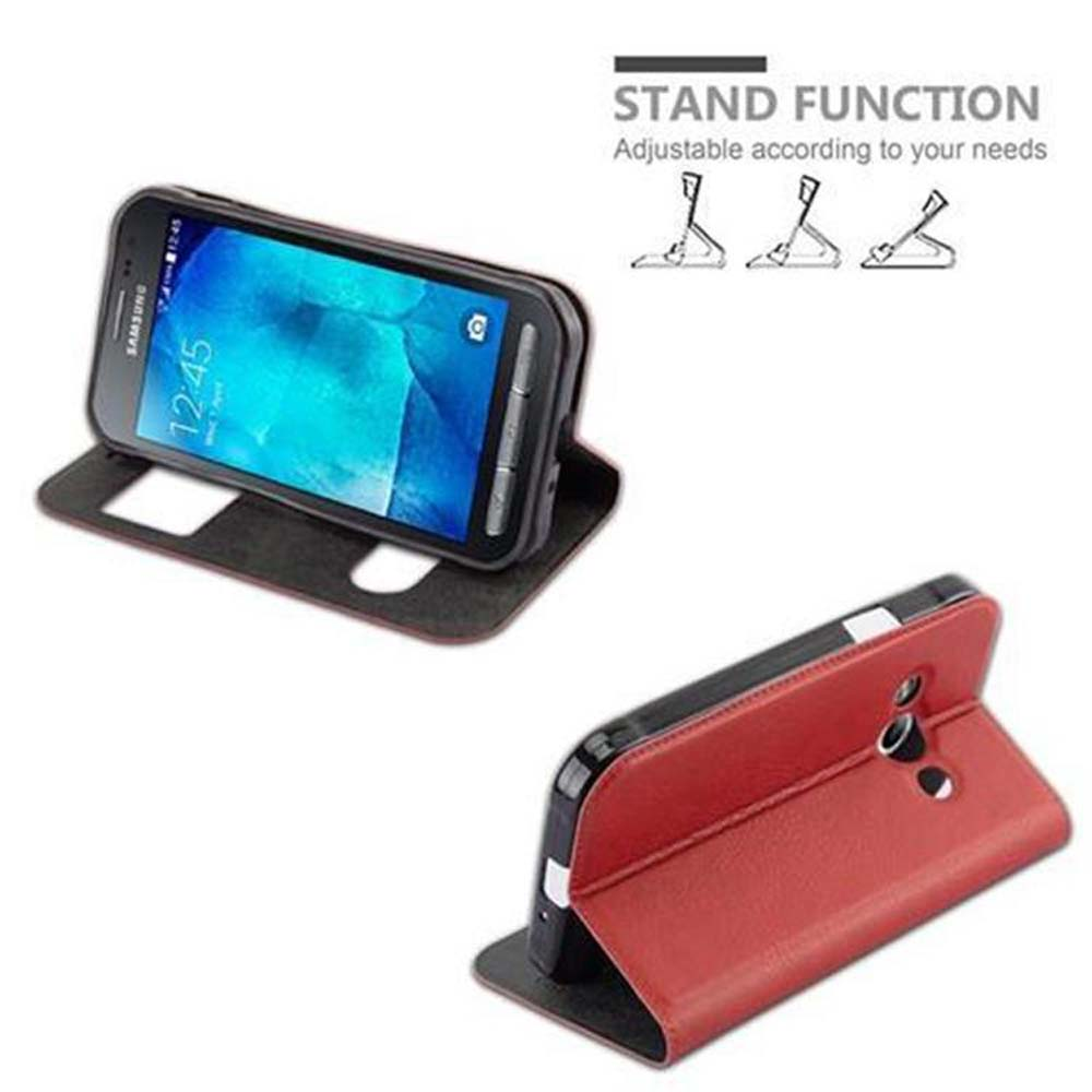Telefoni in custodie con supporto. Un telefono è aperto e in piedi. Un altro telefono in una custodia rossa.