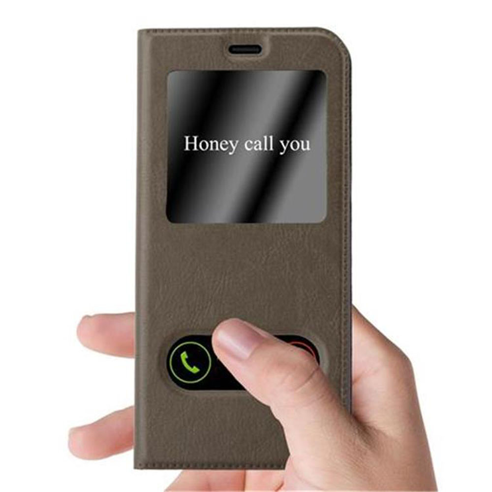 Custodia del telefono marrone chiusa con una finestra con il testo 'Honey call you'. Mano che la tiene.