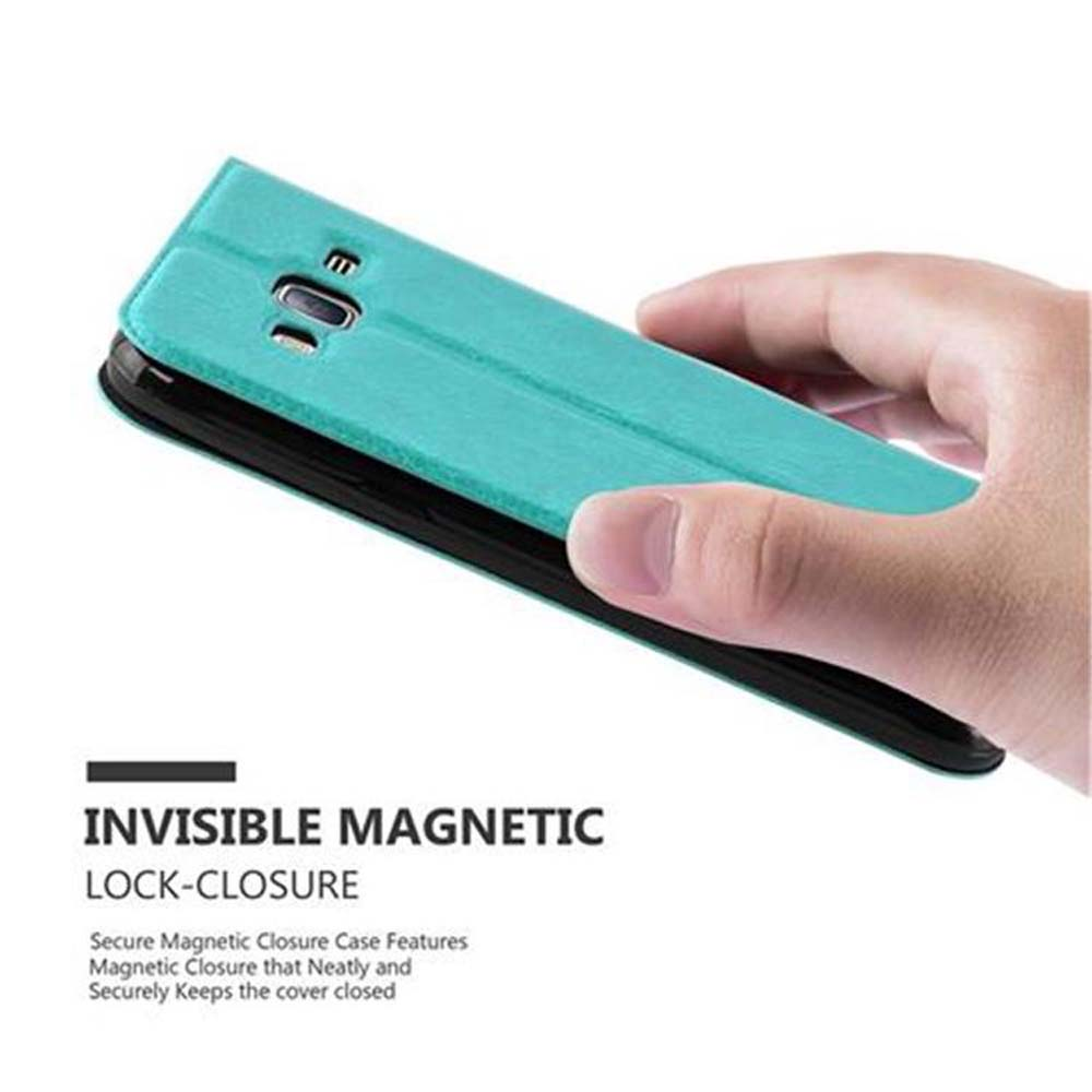 Una mano abre una funda de teléfono color turquesa. Se muestra el cierre magnético. Teléfono no en la funda. Fondo blanco.
