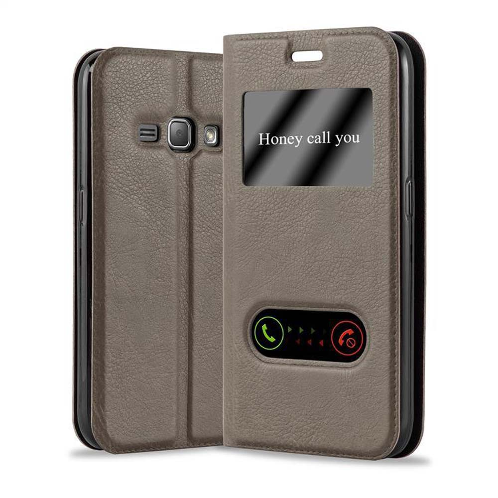 Funda de teléfono marrón con ventana y teléfono dentro. Fondo blanco.