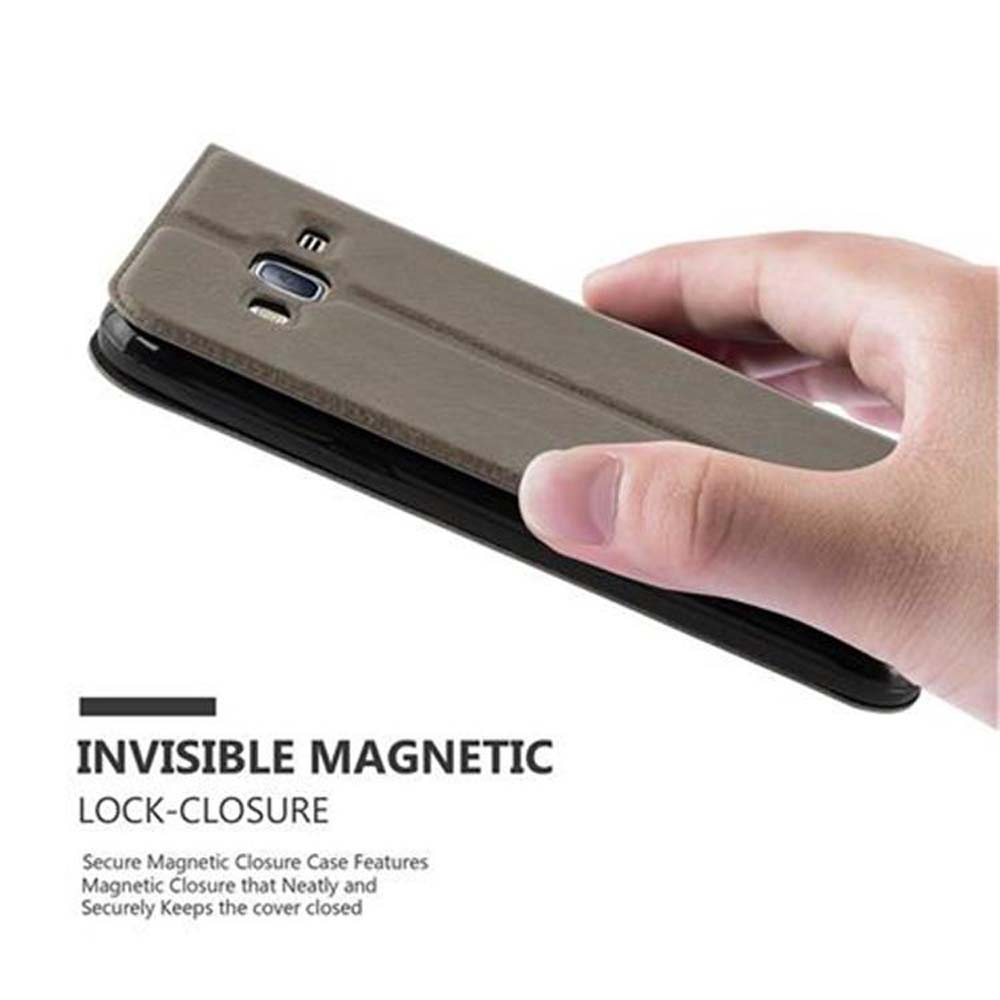 Una mano sostiene una funda de teléfono cerrada. La funda es marrón y tiene un cierre magnético.
