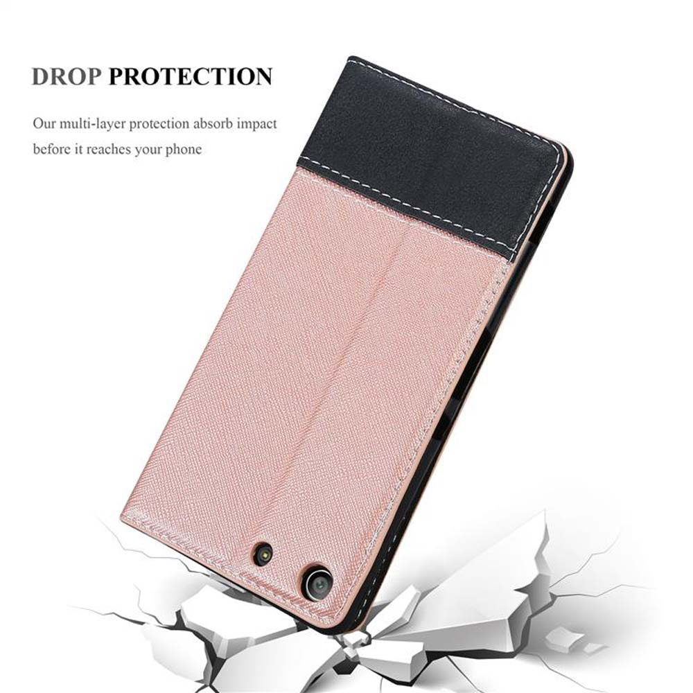 Una funda de teléfono rosa con la parte superior negra, con el texto 'DROP PROTECTION', sobre rocas blancas rotas.