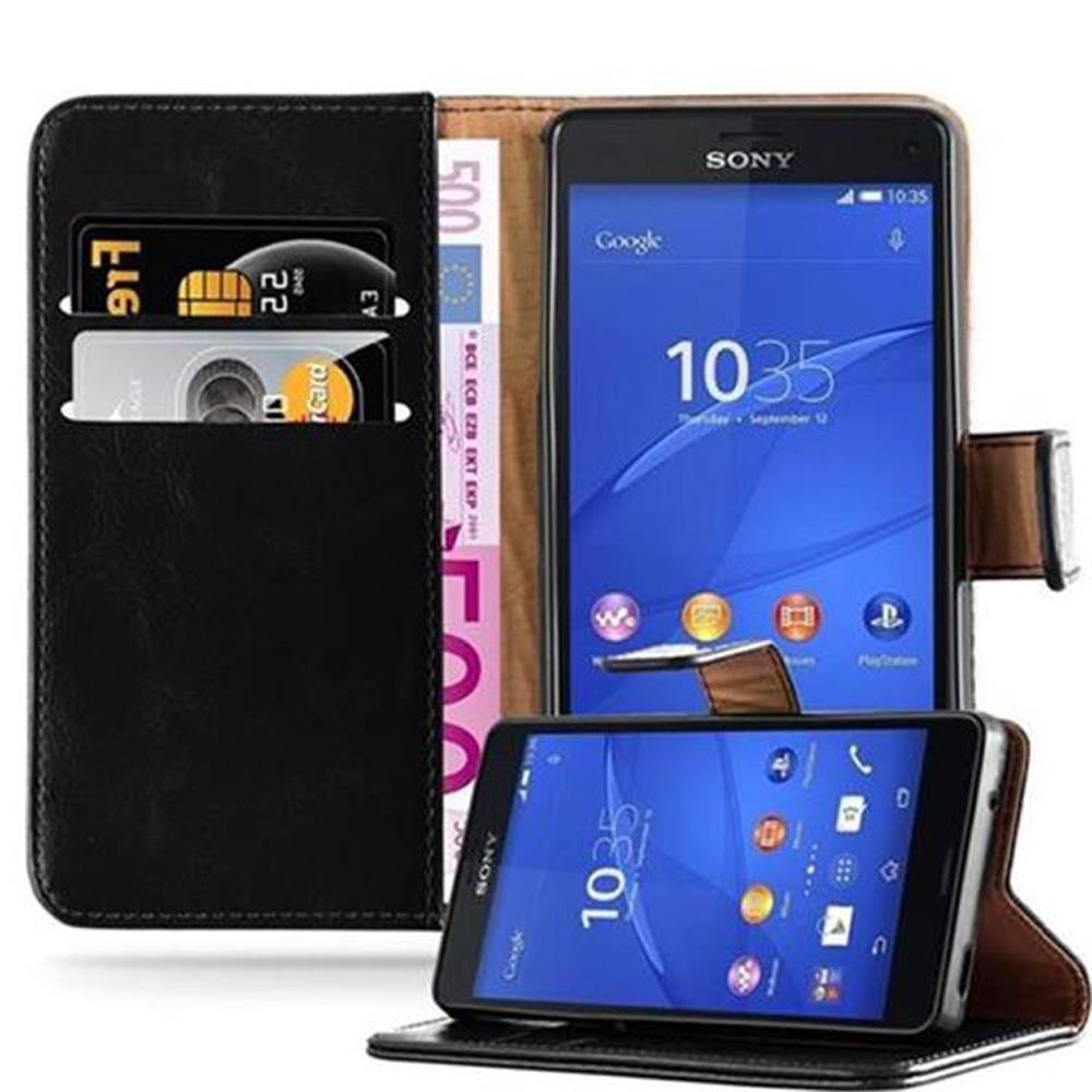 Un teléfono negro en una funda de cuero marrón con una cartera, mostrando tarjetas de crédito y dinero. Sobre superficie blanca.