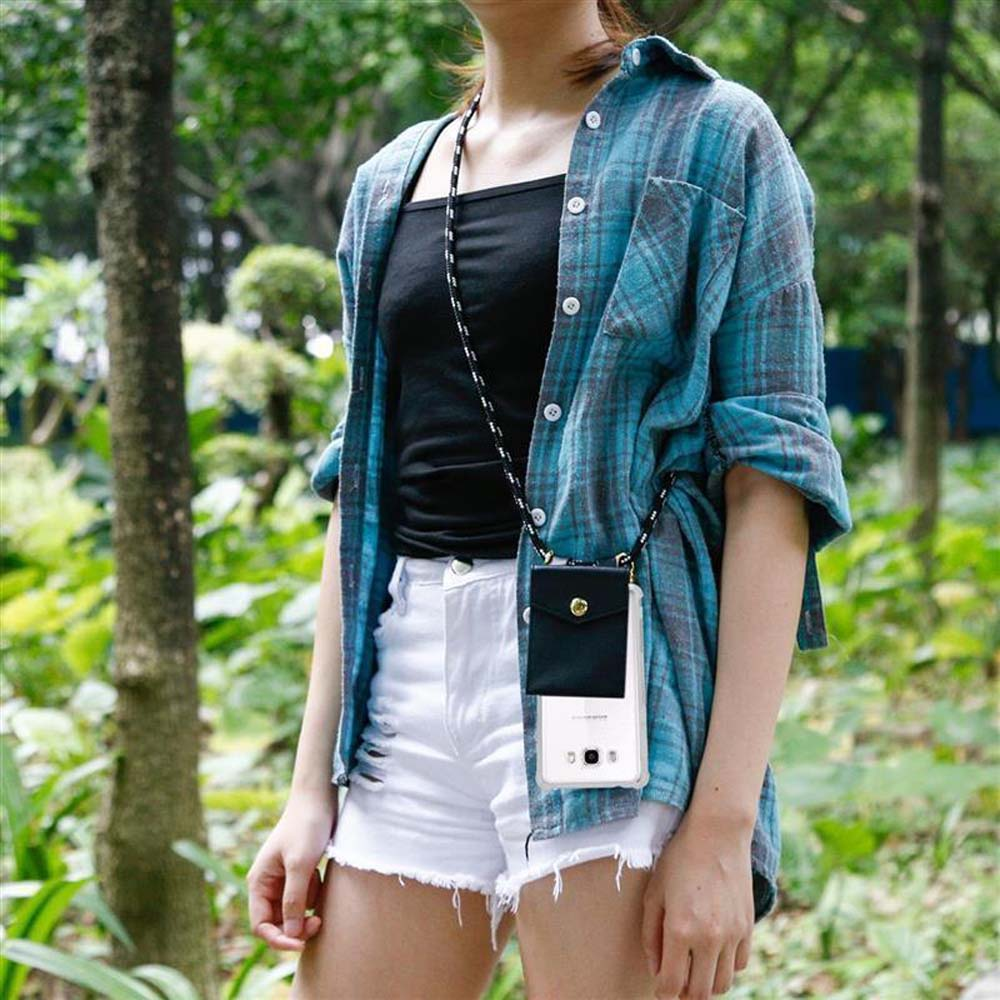 Donna con camicia a quadri blu, pantaloncini bianchi, tiene un telefono in una custodia nera con cinturino, all'aperto.