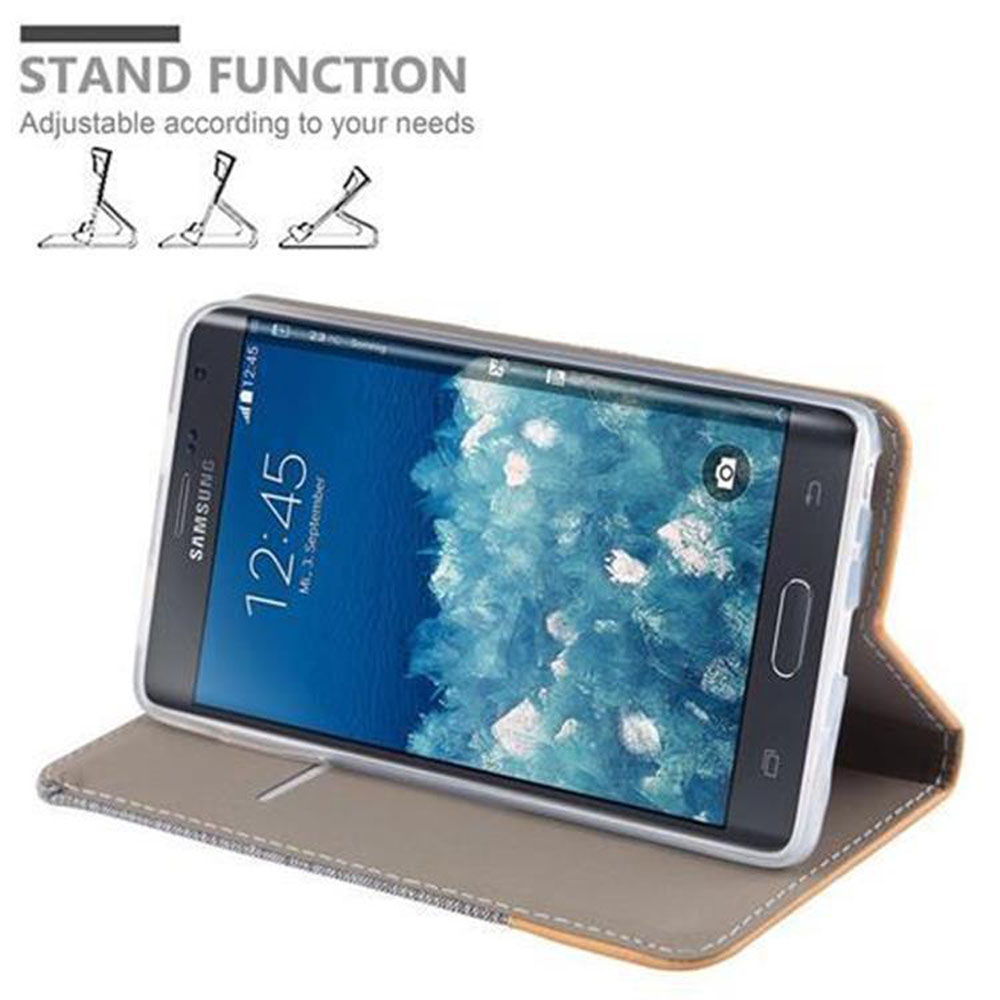 Telefon in einem Gehäuse, auf einem Ständer aufgestellt. Der Bildschirm zeigt 12:45, Samsung-Logo. Ständerfunktion ist gezeigt.