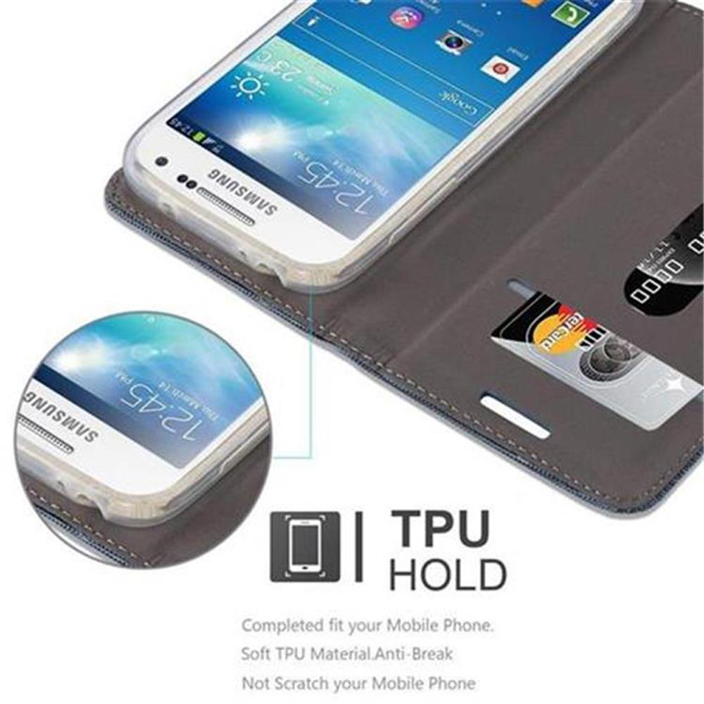 Un teléfono en una funda tipo cartera con ranuras para tarjetas de crédito. La pantalla es visible. La funda es gris.