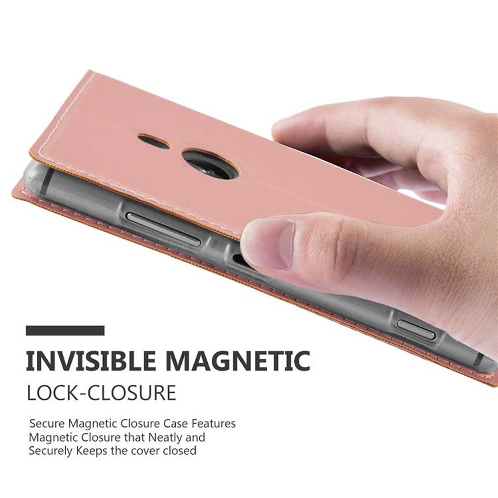 Main tenant un étui de téléphone rose. L'étui est fermé avec une fermeture magnétique invisible.