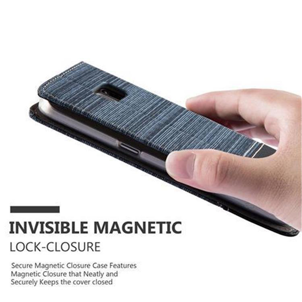 Una mano che tiene una custodia per telefono con texture denim, con un'etichetta di chiusura magnetica invisibile.