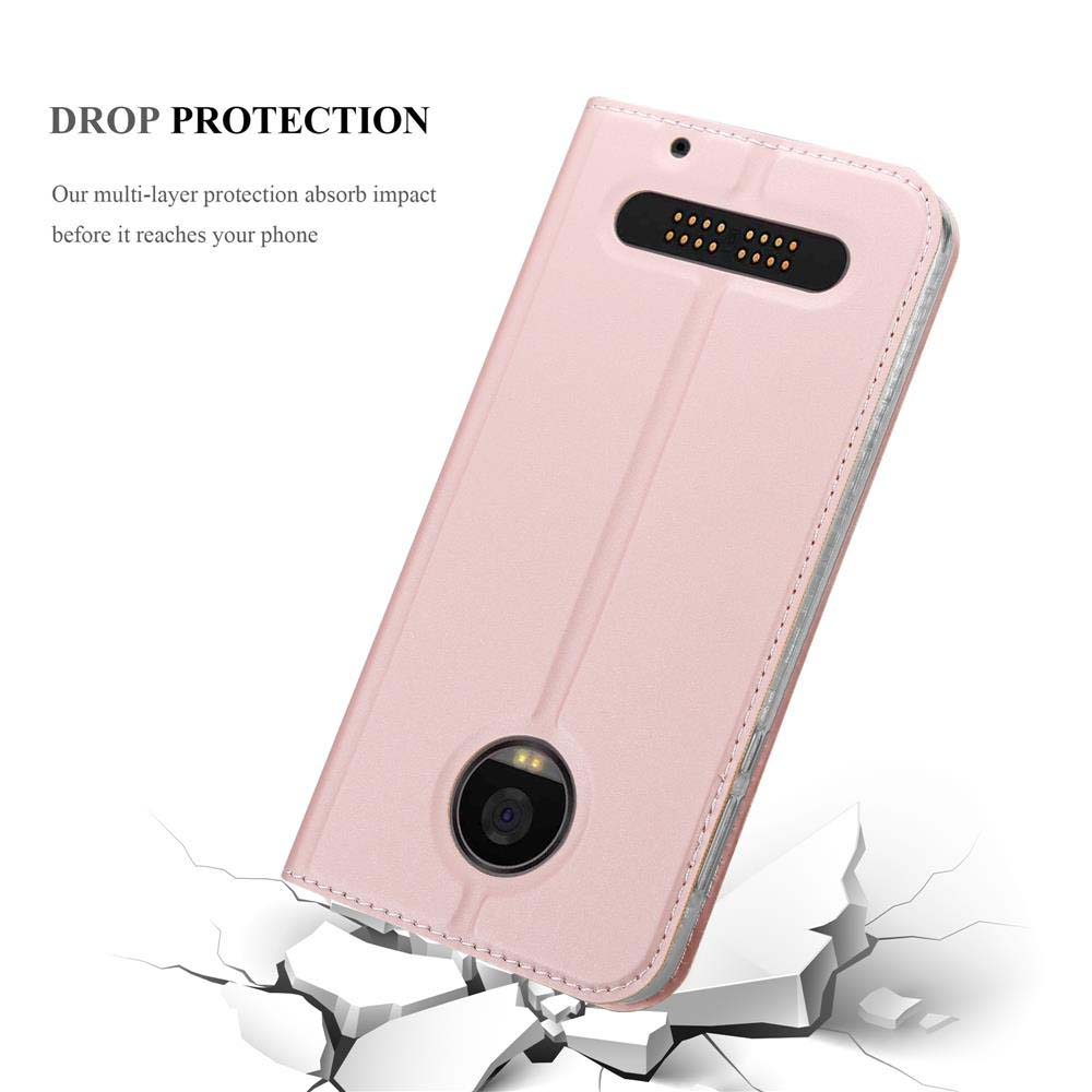 Custodia rosa inclinata per mostrare una fotocamera. Sfondo bianco e quello che sembra essere vetro rotto.