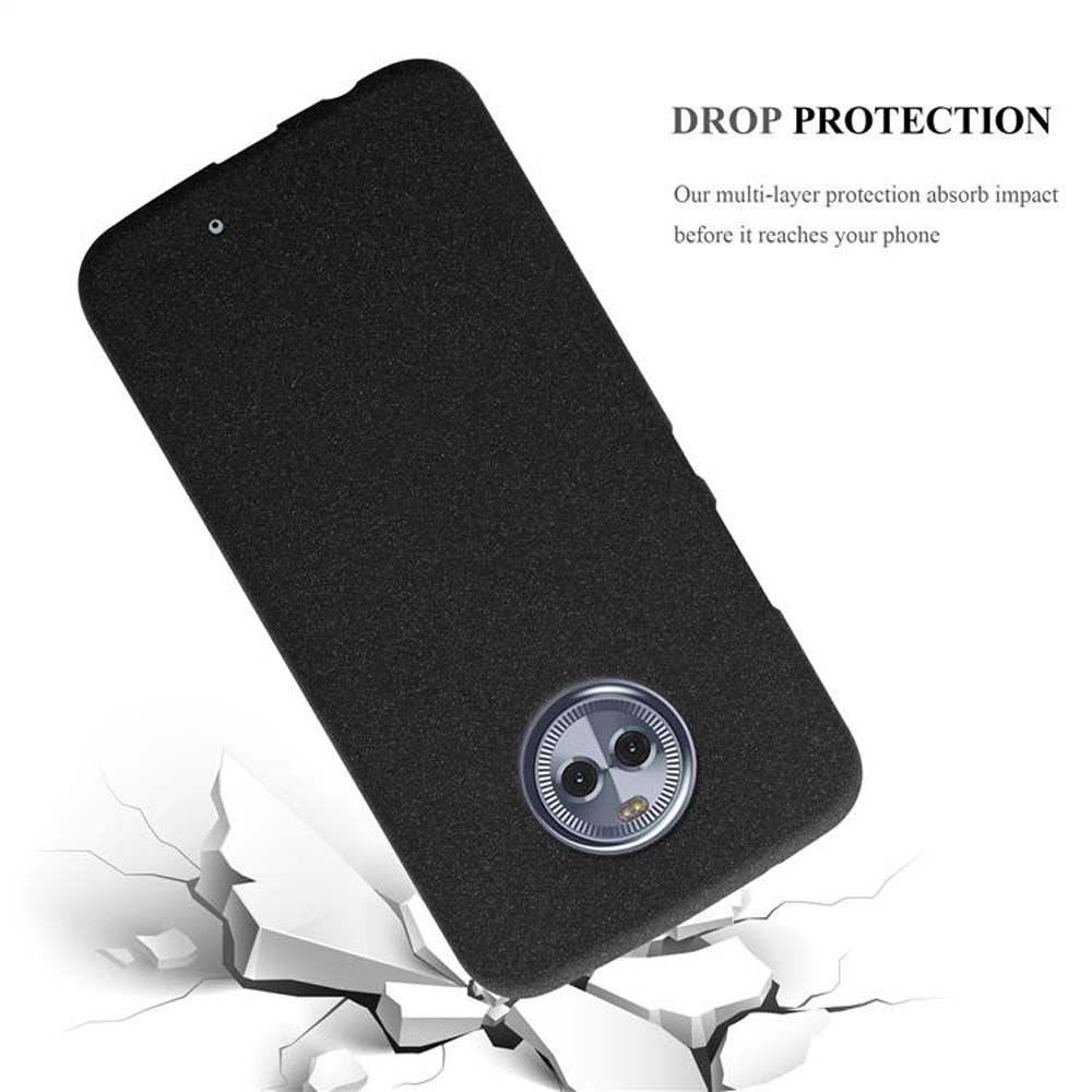 Funda negra para teléfono cayendo. La funda tiene un recorte para la cámara. El fondo es un suelo destrozado.