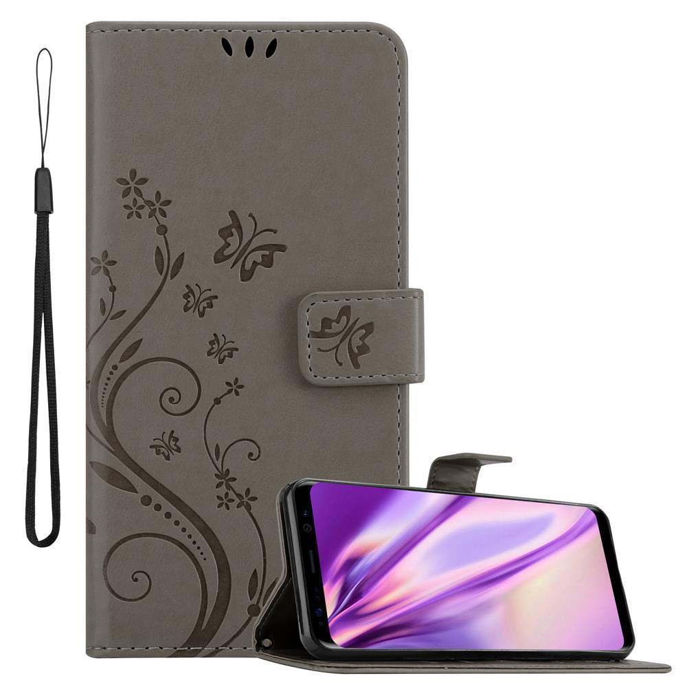 Custodia grigia con design floreale e cinturino nero. Telefono visibile.