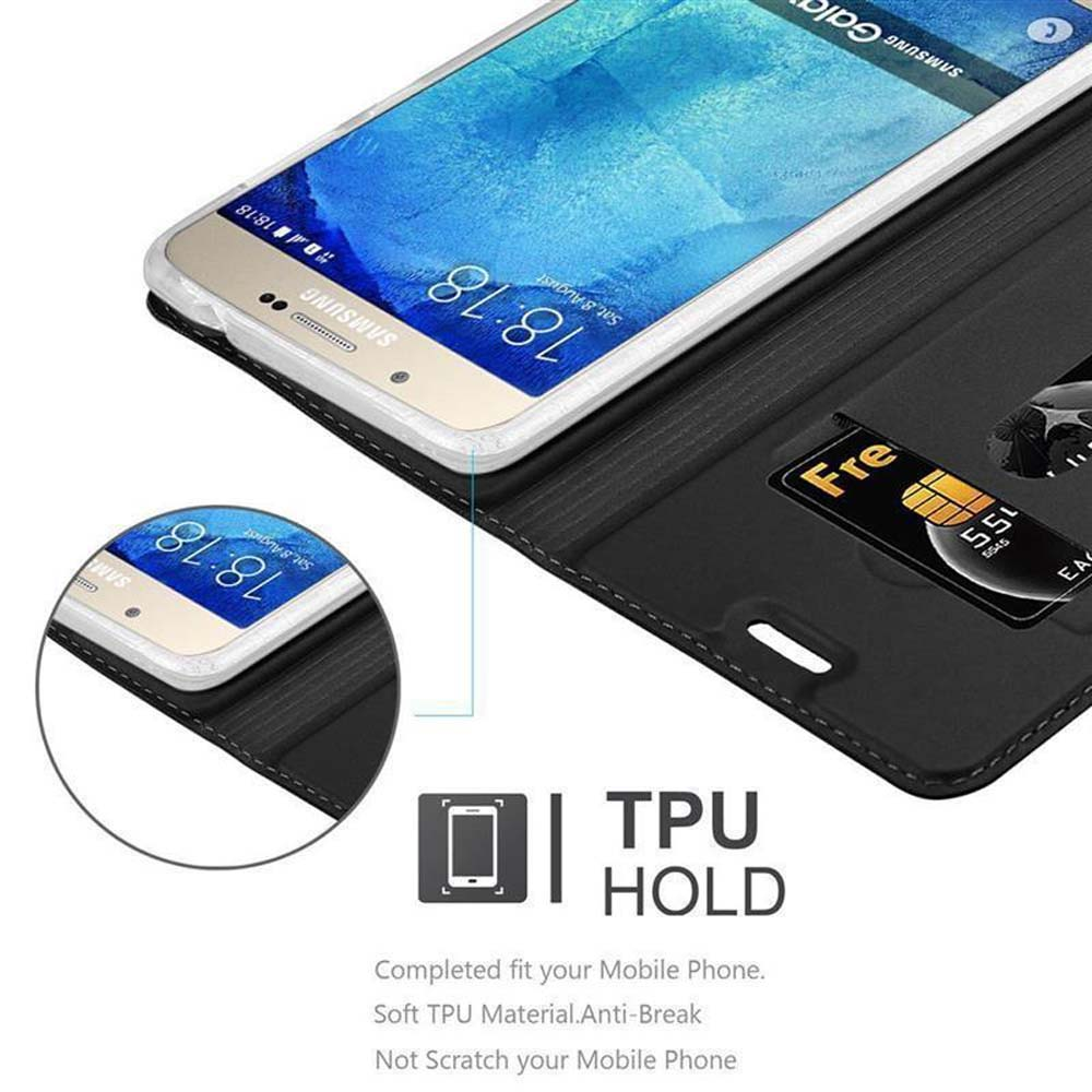 Eine schwarze Handyhülle mit einem Telefon darin. Das Telefon zeigt Zeit und Datum an. Schwarzer Hintergrund.