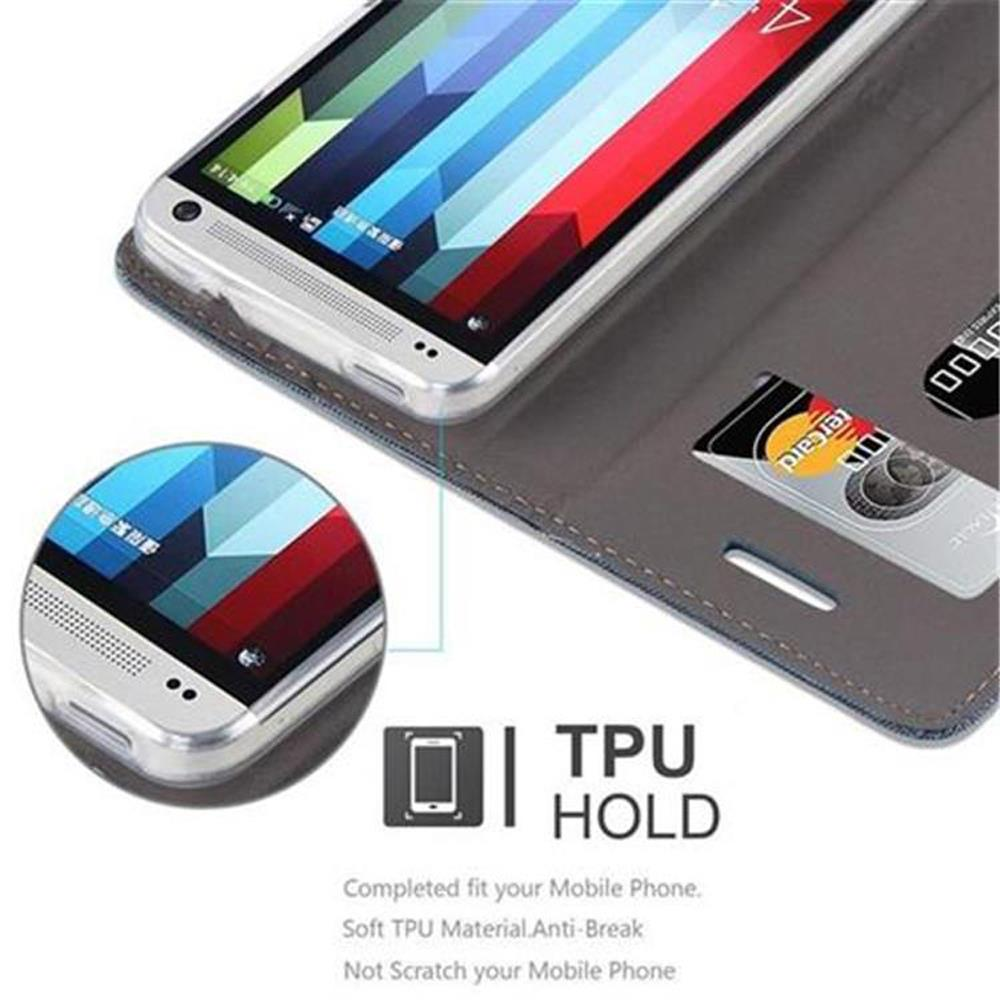 Teléfono en funda. La funda es gris y tiene una ranura para tarjeta de crédito. El texto dice TPU HOLD. Hay un círculo que muestra el teléfono.