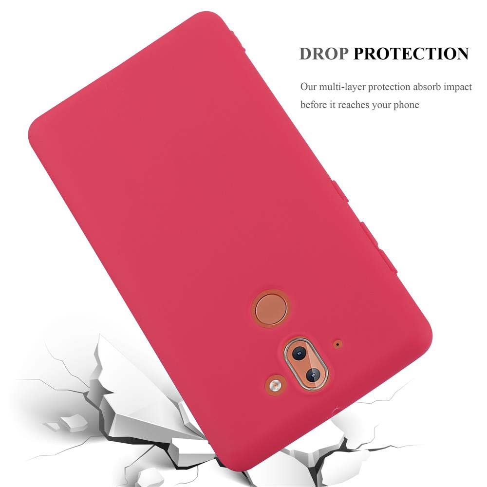 Custodia rossa per telefono con fotocamera, che cade su terreno bianco rotto.