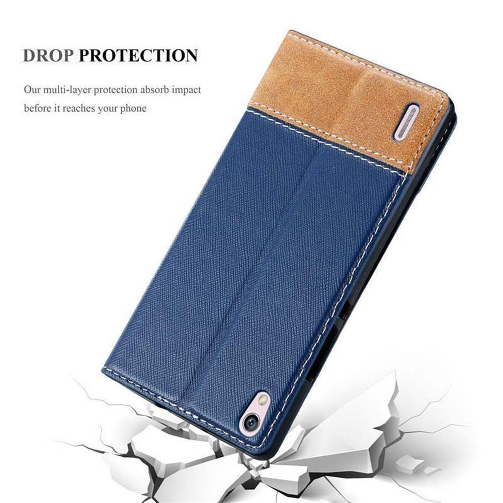 Funda azul para teléfono con parte superior marrón. La funda está abierta y sobre una superficie rota.