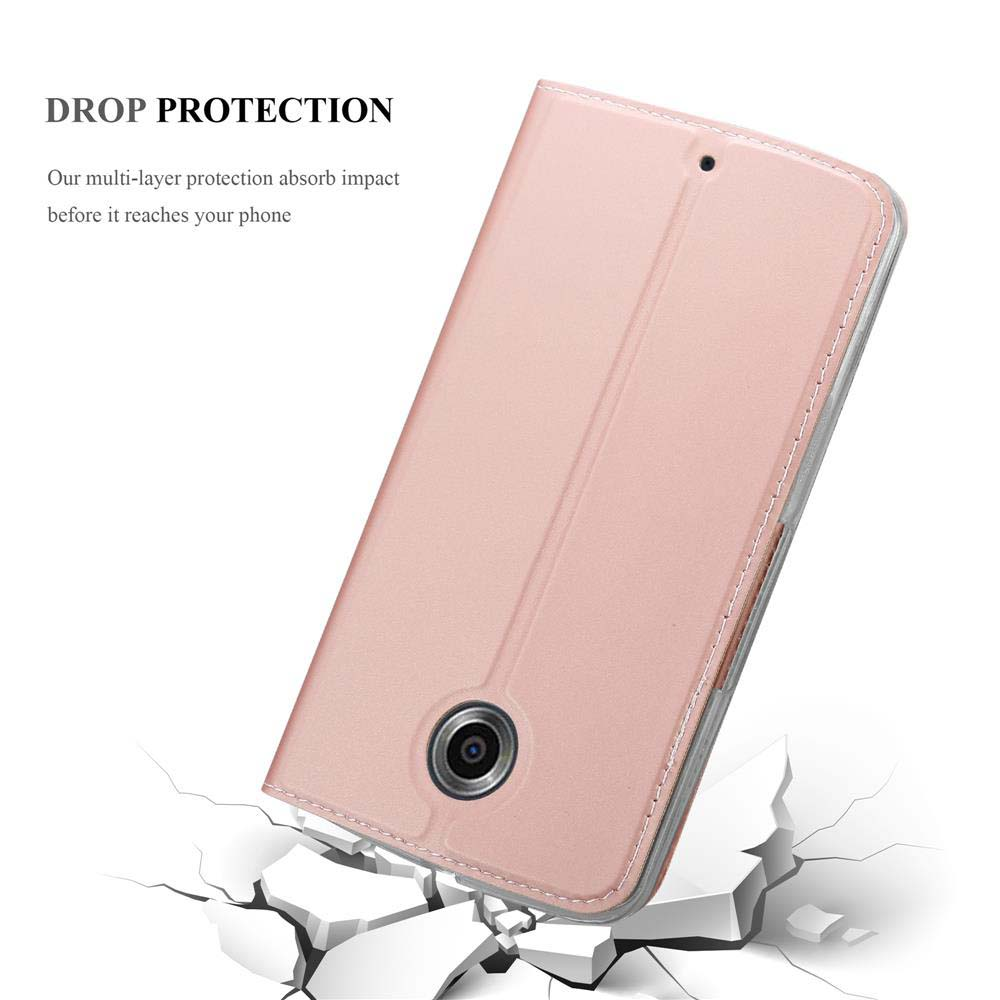 Teléfono rosa en una funda rosa. La funda está en una superficie, con trozos rotos alrededor.