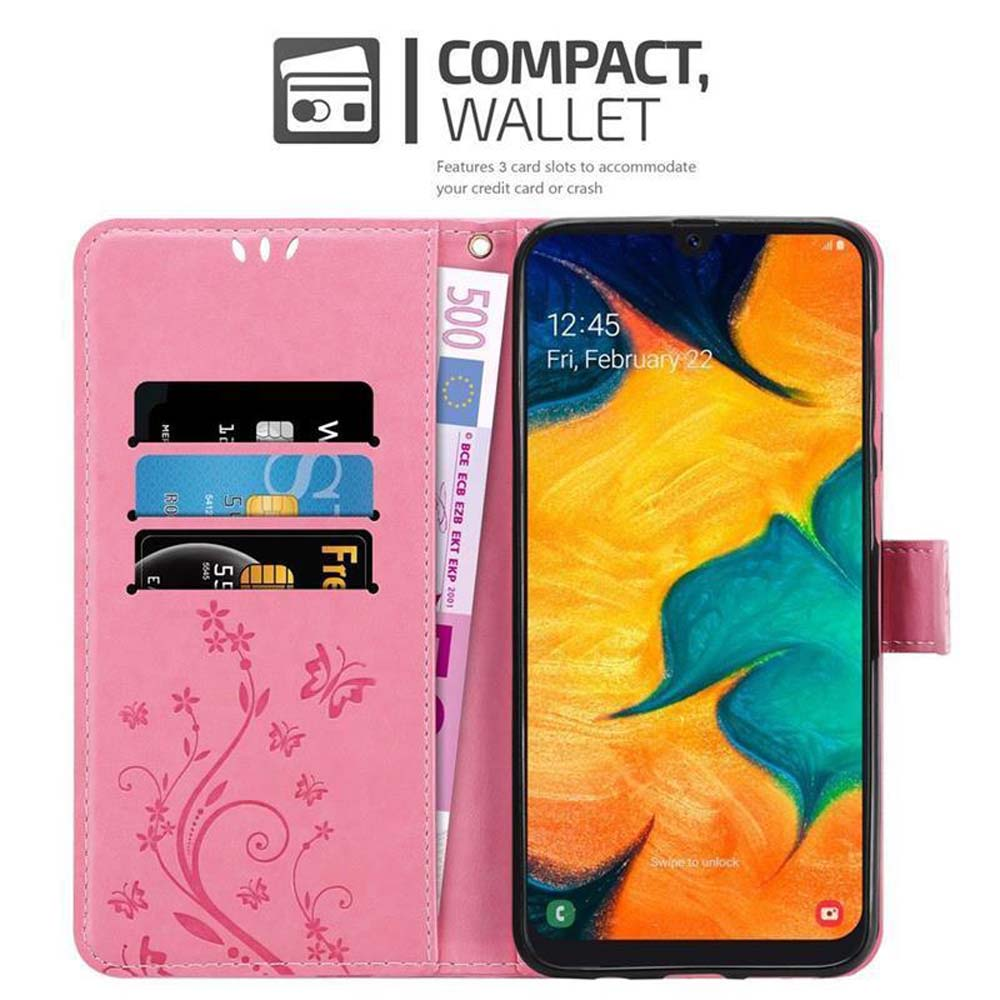 Una custodia rosa per telefono con un telefono all'interno. Carte e denaro sono all'interno della custodia.