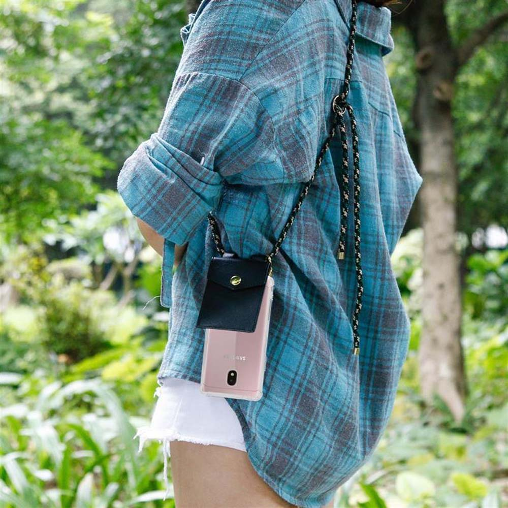 Una persona che indossa una camicia a quadri blu con un telefono in una custodia nera appeso a un cordino.