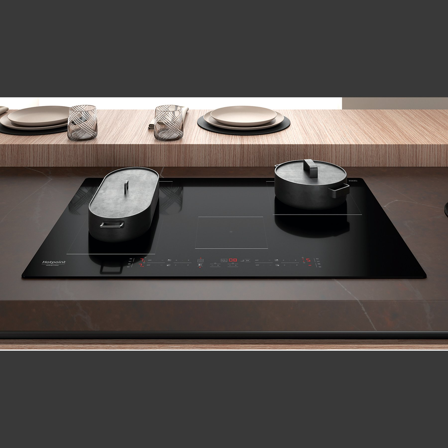 Czarna płyta indukcyjna z dwoma garnkami. Widoczne pokrętła i wyświetlacz cyfrowy.