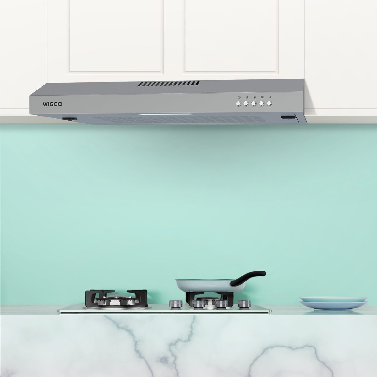 Keuken met een grijze afzuigkap boven een fornuis en een lichtblauwe muur.