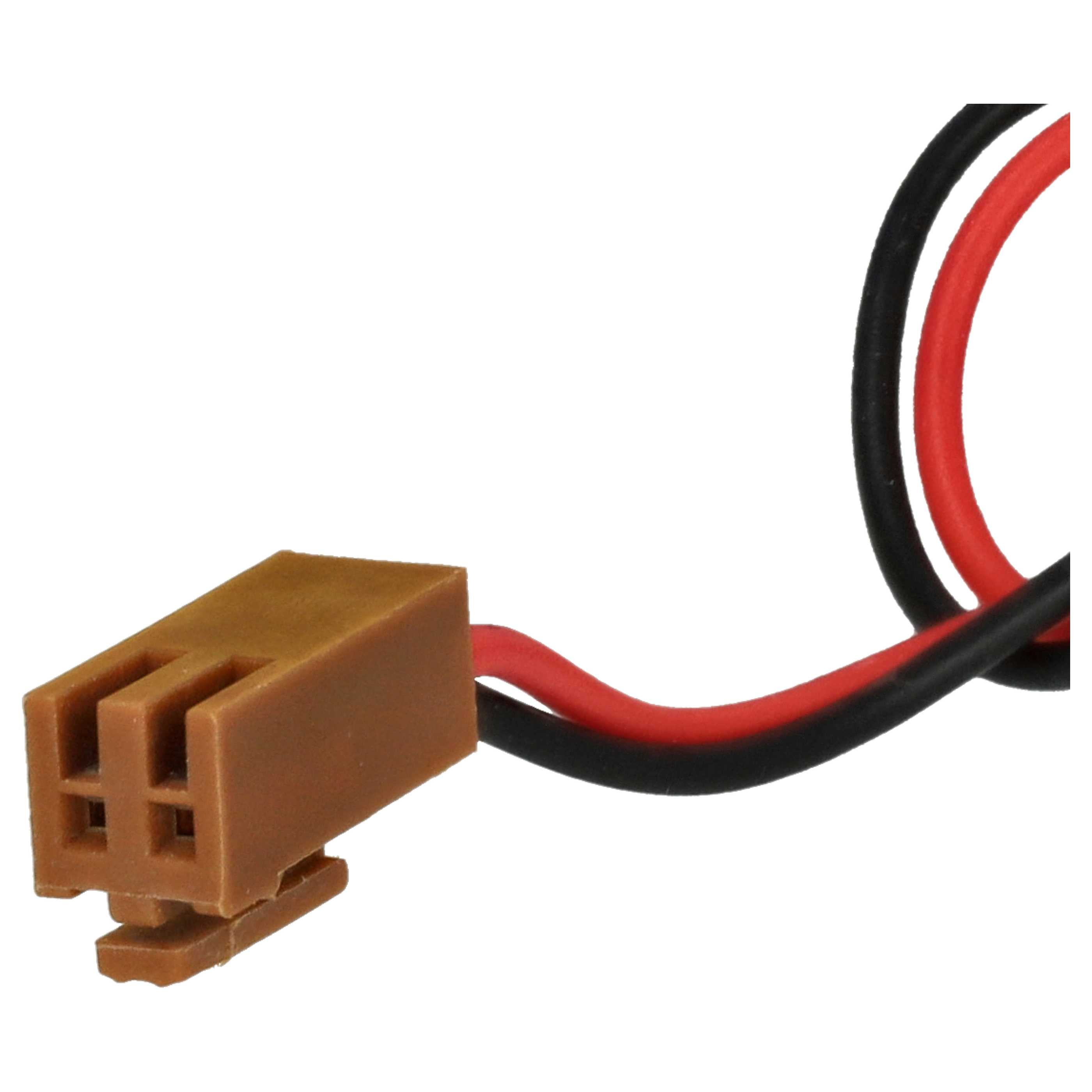 Ein brauner Kunststoffstecker mit drei Schlitzen und roten und schwarzen Drähten.