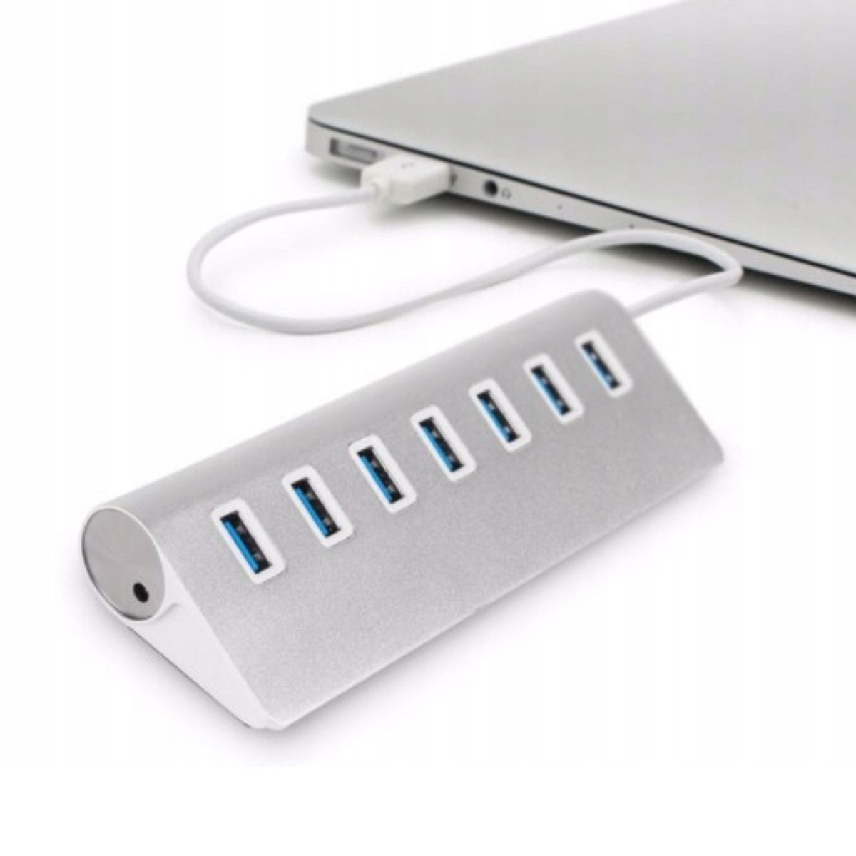 Srebrny hub USB podłączony do laptopa. Hub ma wiele portów USB z niebieskim wnętrzem.
