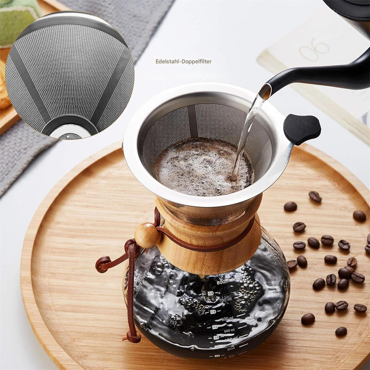 Ein Kaffee-Pour-Over-Setup. Ein Holztablett, eine Glaskaraffe, ein Filter und Kaffeebohnen werden gezeigt.
