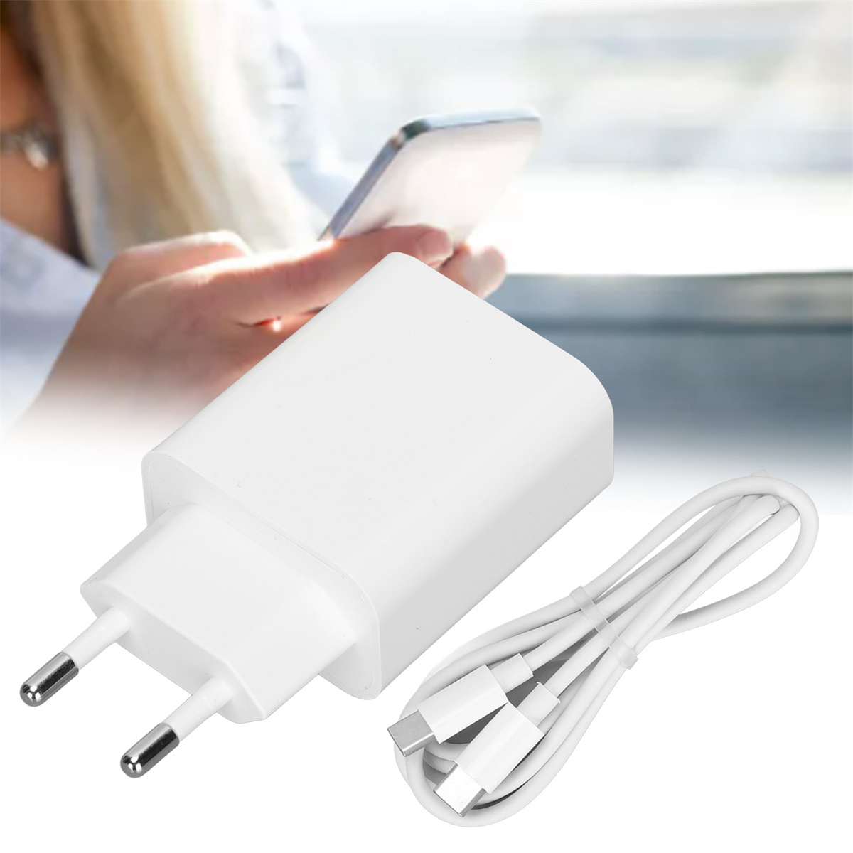 Weißes Ladegerät und Kabel, im Hintergrund eine Frau, die ein Telefon benutzt.