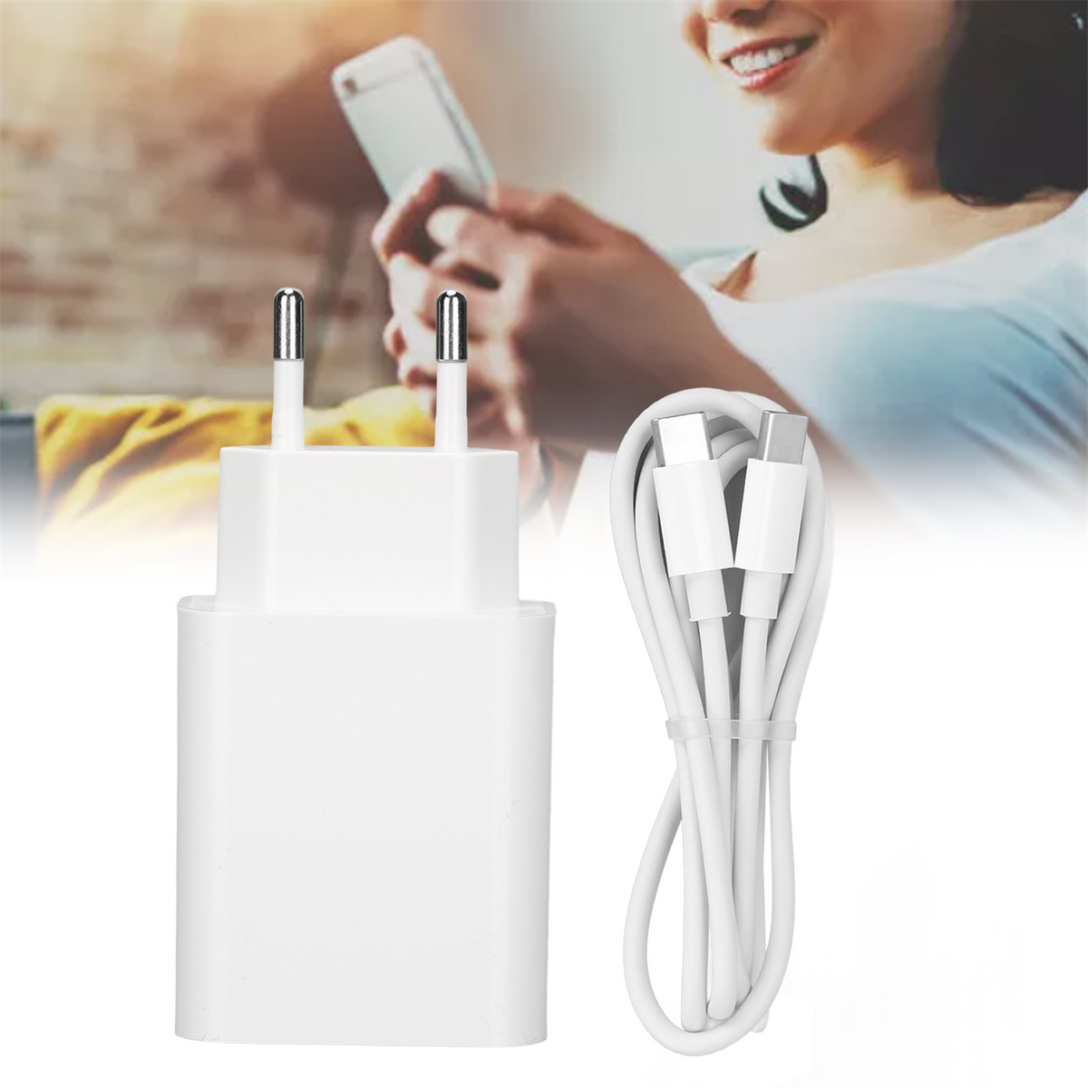Weißes Ladegerät und Kabel neben einer Person, die ein Telefon benutzt.