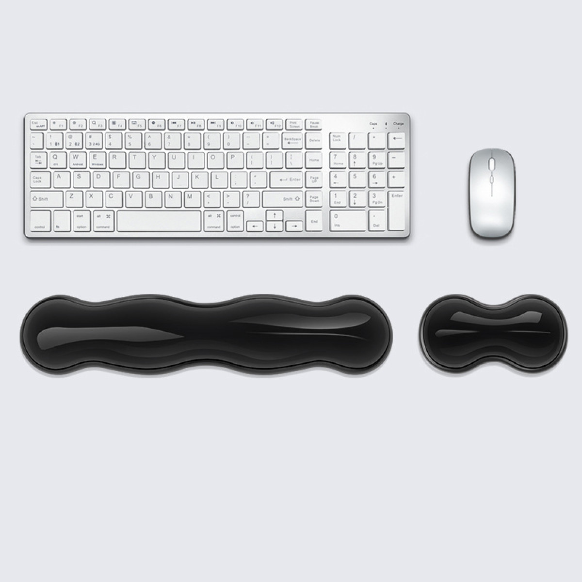 Eine weiße Tastatur, Maus und zwei schwarze Handgelenkauflagen. Sie sind vor einem hellgrauen Hintergrund angeordnet.