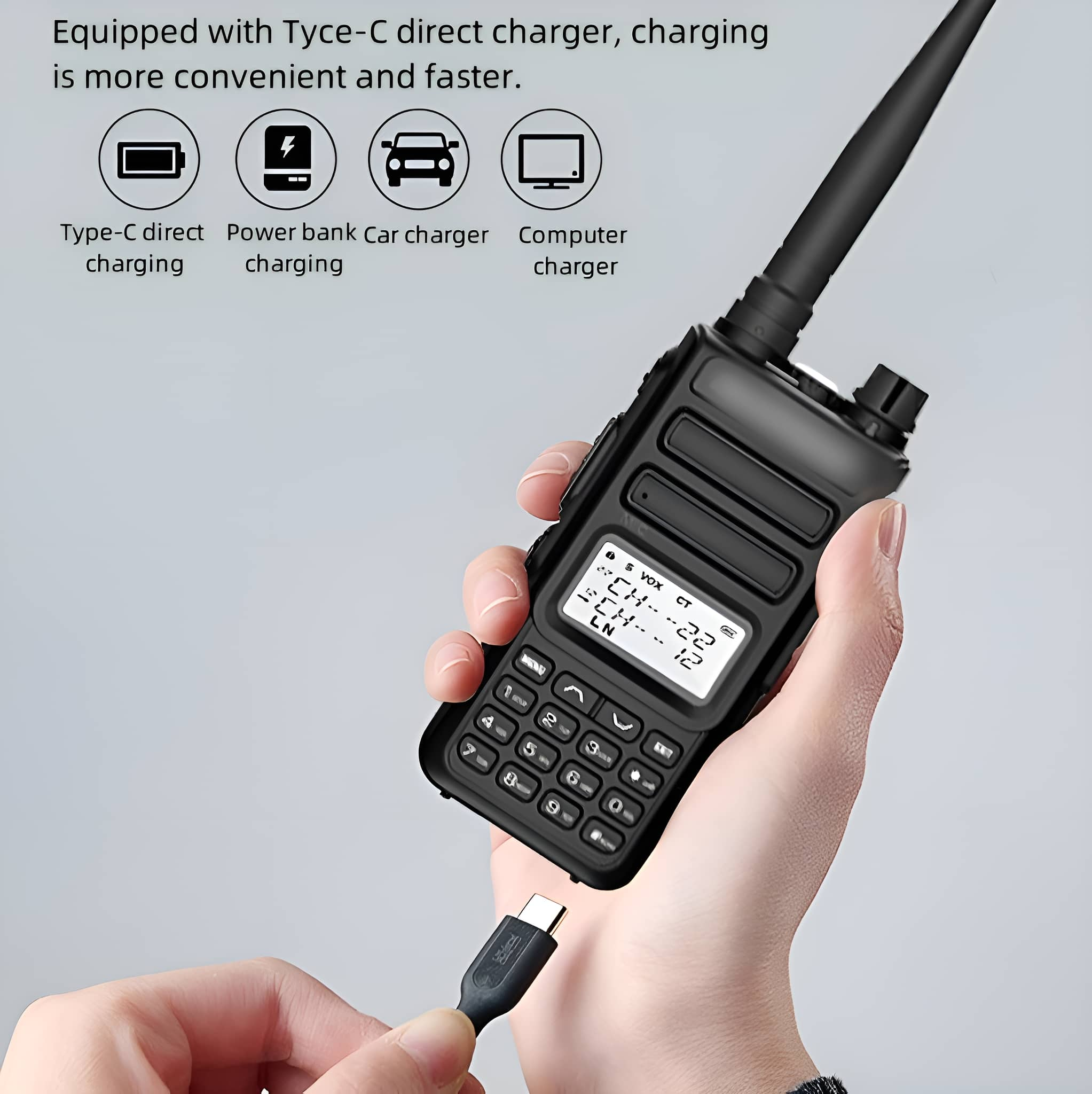 Schwarzes Walkie-Talkie mit eingestecktem USB-Kabel, gehalten von einer Person. Laden angezeigt.