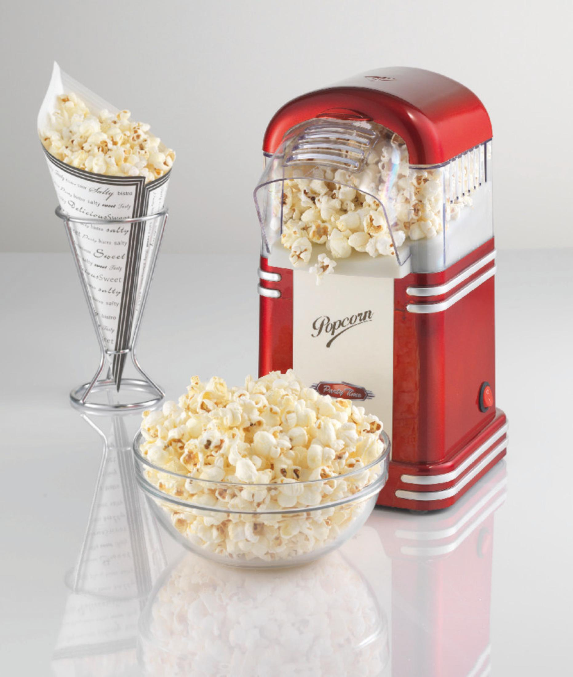 Macchina per popcorn retrò rossa con un cono di popcorn e una ciotola di popcorn. Sfondo bianco e riflesso.