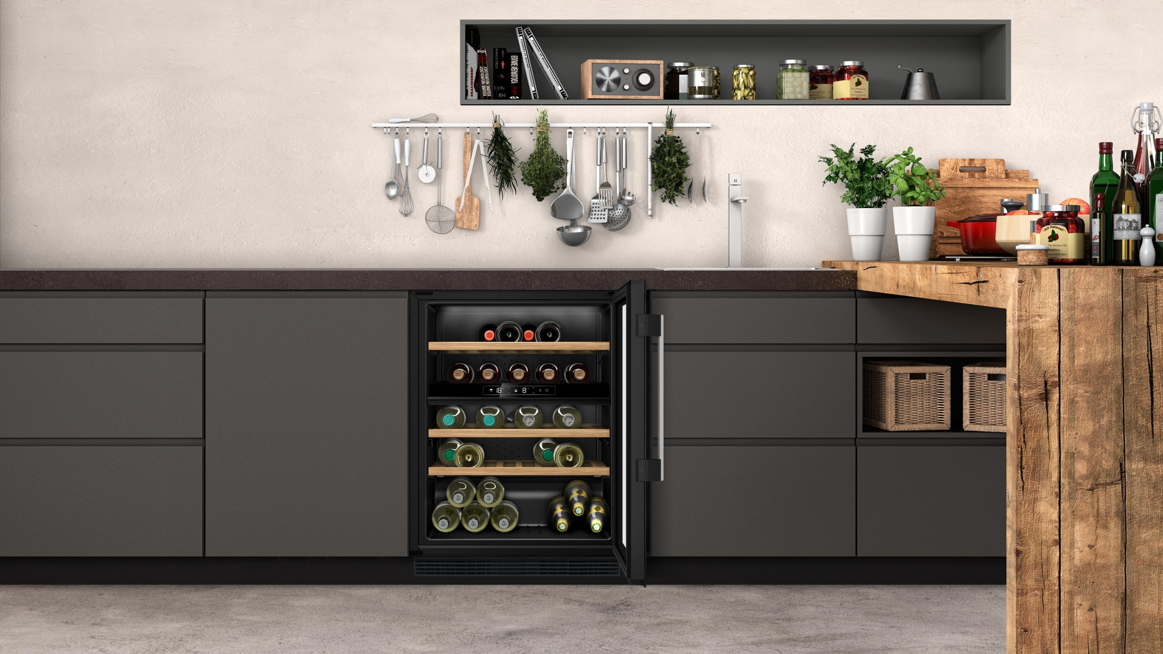 Küche mit offenem Weinkühlschrank, dunklen Schränken, hängenden Utensilien und Holzküchentheke.