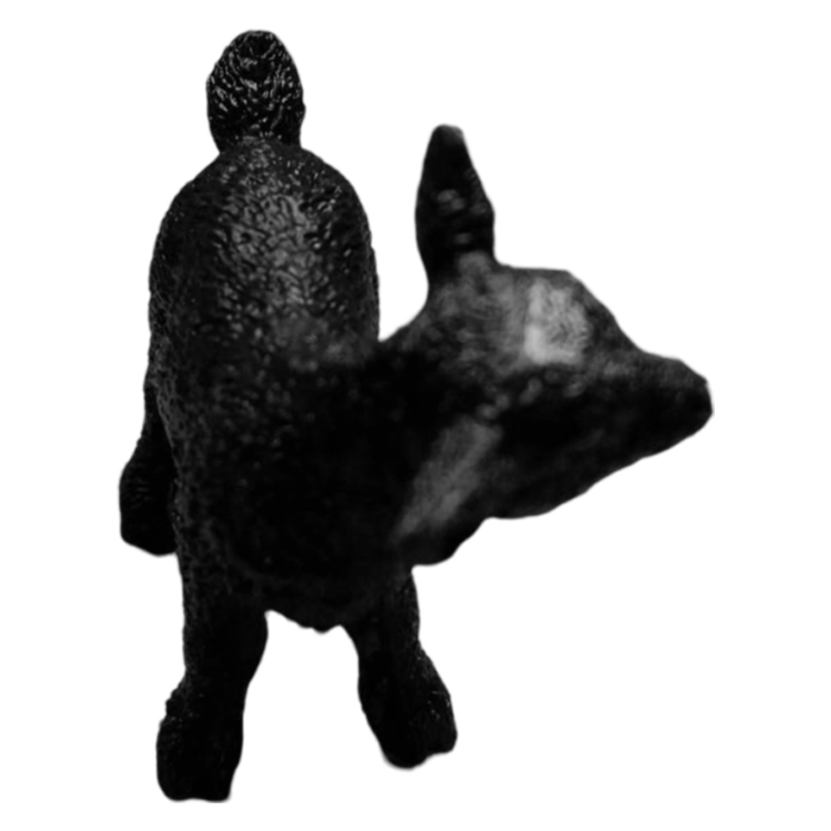 Una statua di scimpanzé nera, vista da dietro e di lato, con la testa girata.