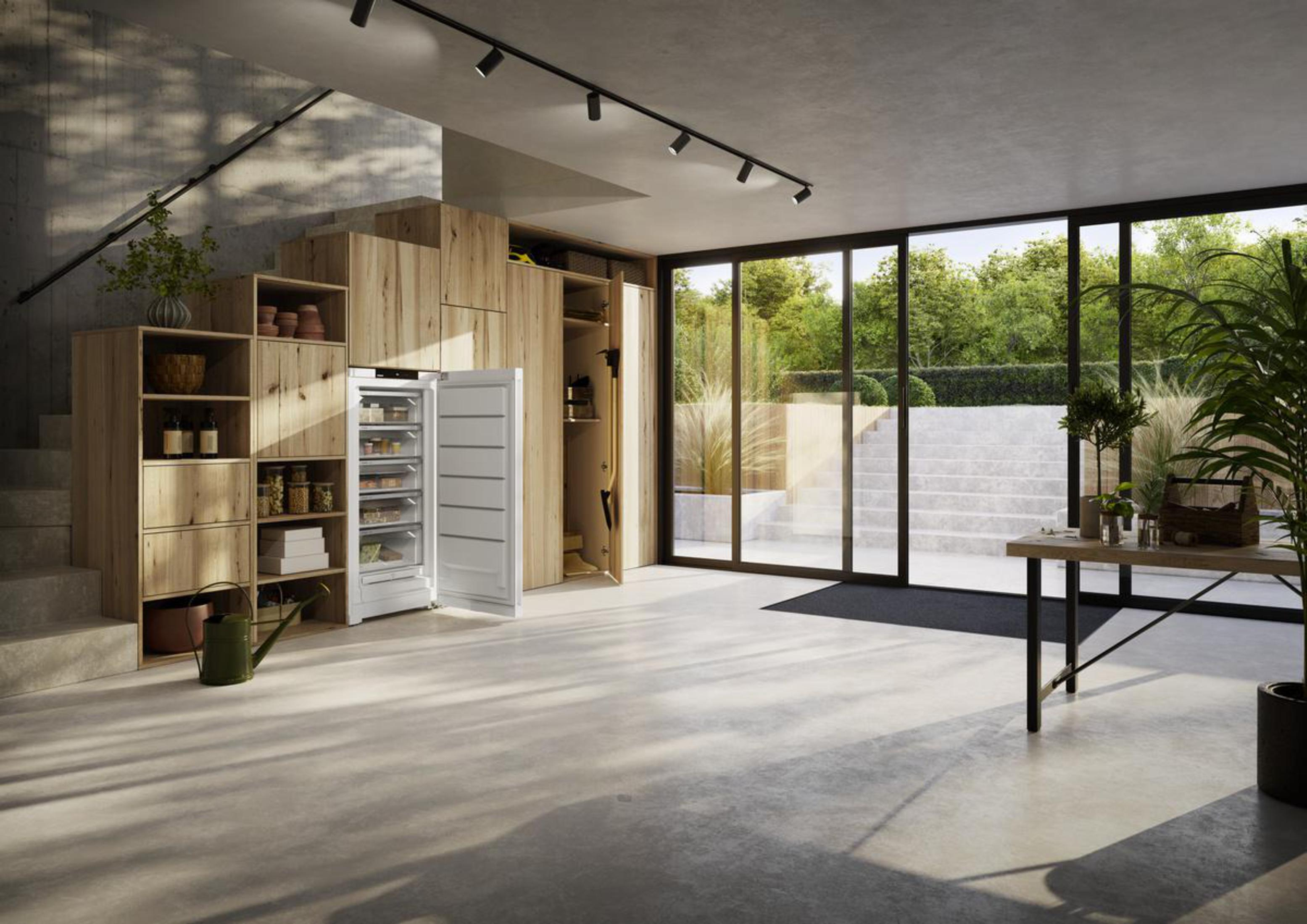 Modernes Interieur mit Kühlschrank, Holzregalen und Naturblick.