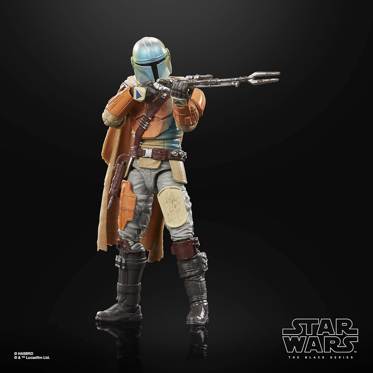 Una action figure di Star Wars Mandalorian, in armatura, che punta un'arma su sfondo nero.