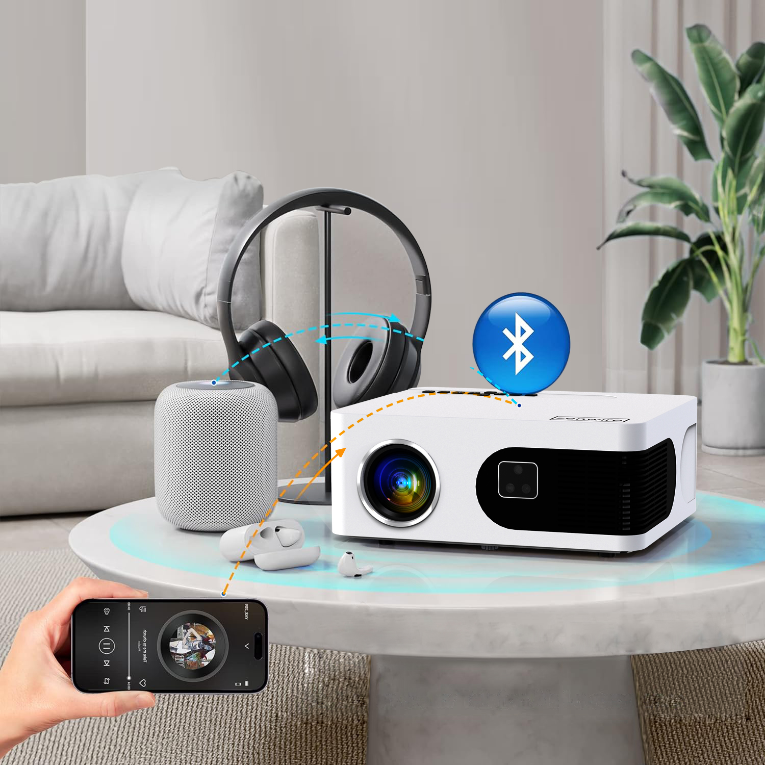 Projektor, słuchawki i głośnik stoją na stole. Telefon kontroluje projektor.