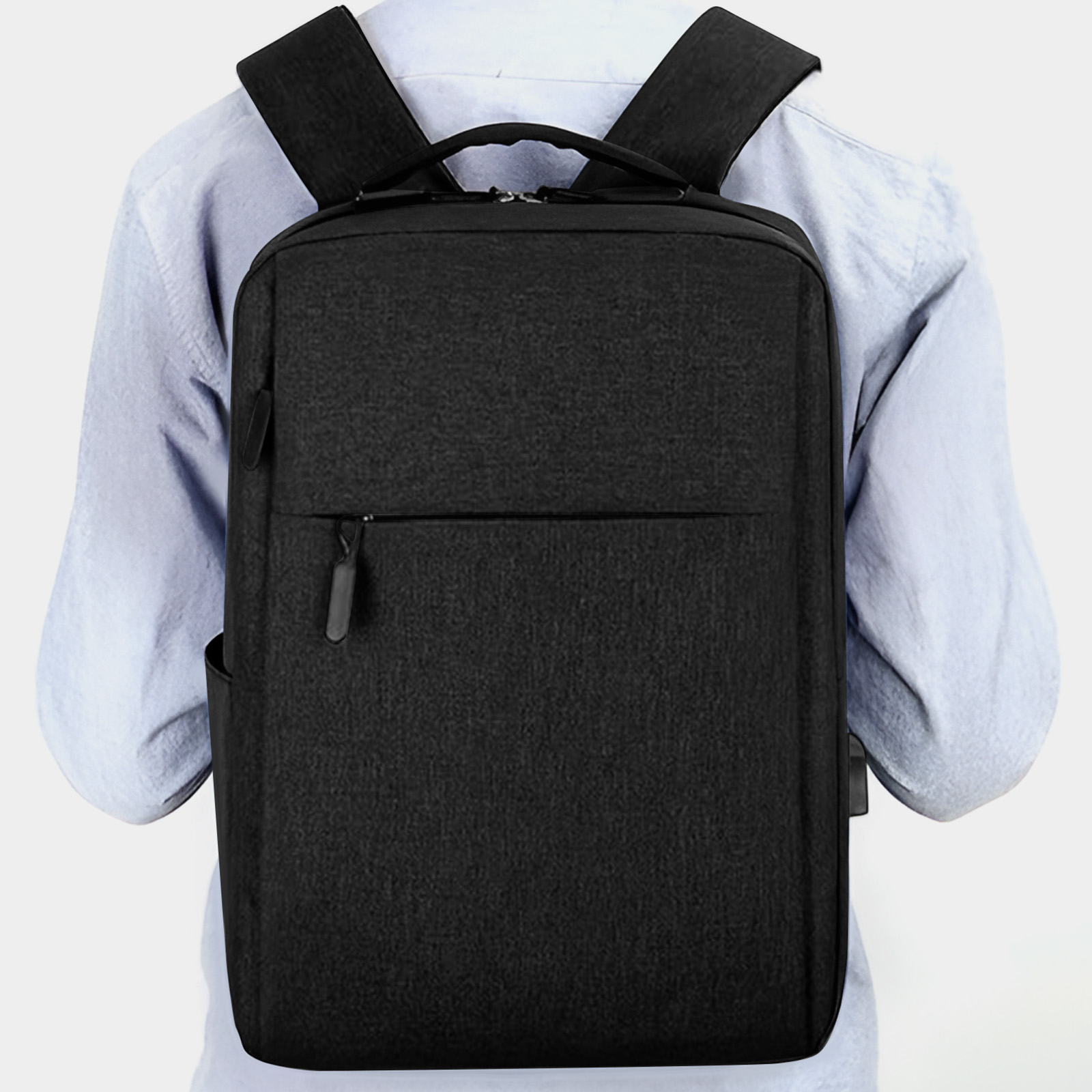 Schwarzer Rucksack auf einer Person. Hat eine Vordertasche und einen Reißverschluss.
