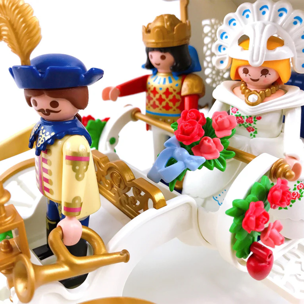 Playmobil-Figuren in einer weißen Kutsche. Ein Mann, ein König und eine Frau im weißen Kleid sind zu sehen.