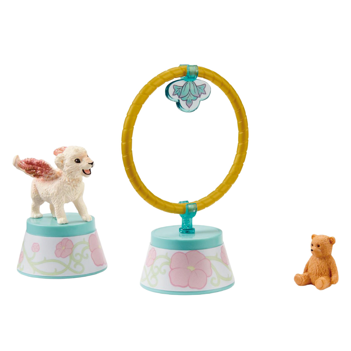 Set di giocattoli con un cagnolino, un orsacchiotto e un cerchio dorato. Sono su basi colorate.