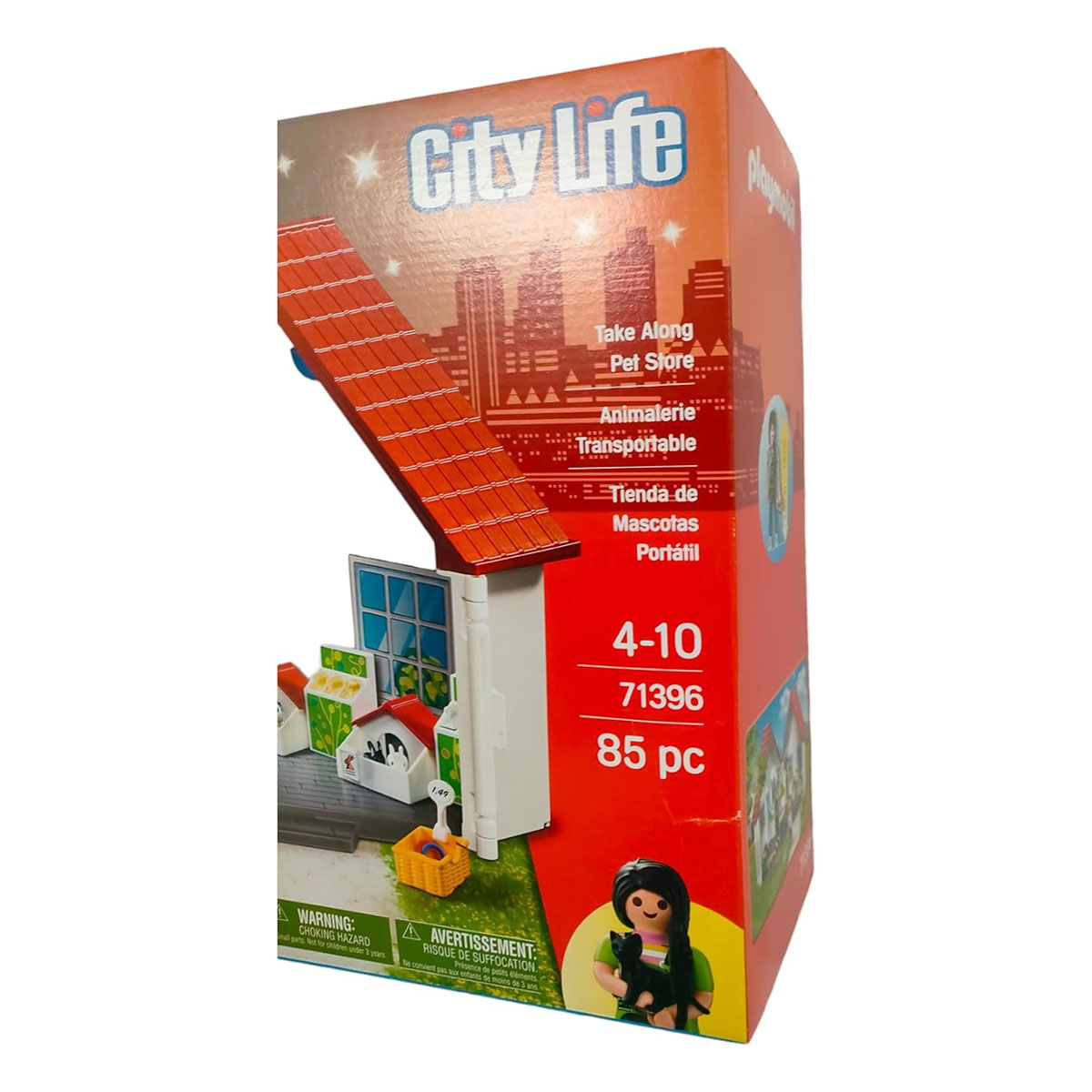 Eine Spielzeugkiste mit einem Haus und einer Kinderfigur. Auf der Box steht 'City Life' und 'Take Along'.