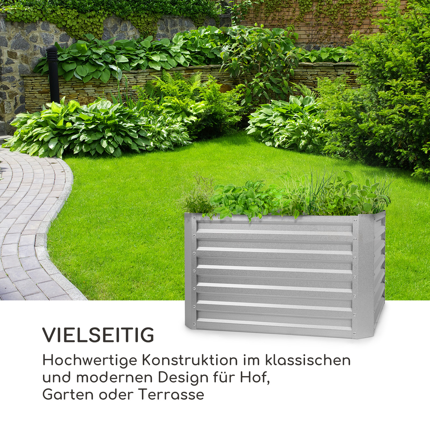 Ein metallisches Hochbeet, bepflanzt. Grünes Gras und Steinmauer im Hintergrund. Das Wort 