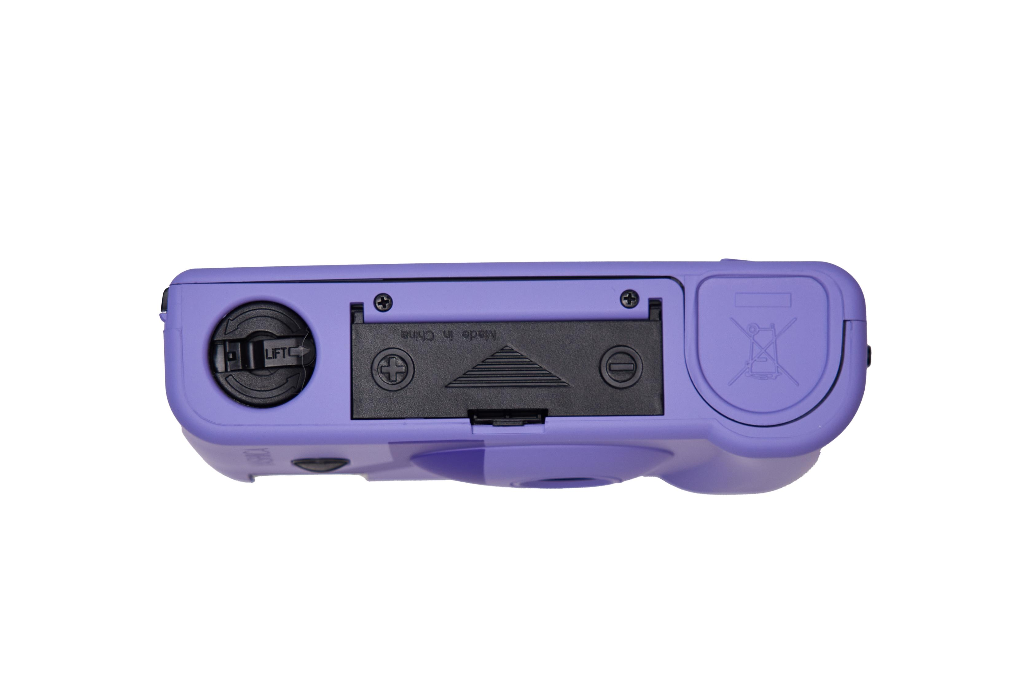 Lo scomparto batterie di una fotocamera viola è aperto, rivelando le batterie. La scritta "Made in China" è visibile.