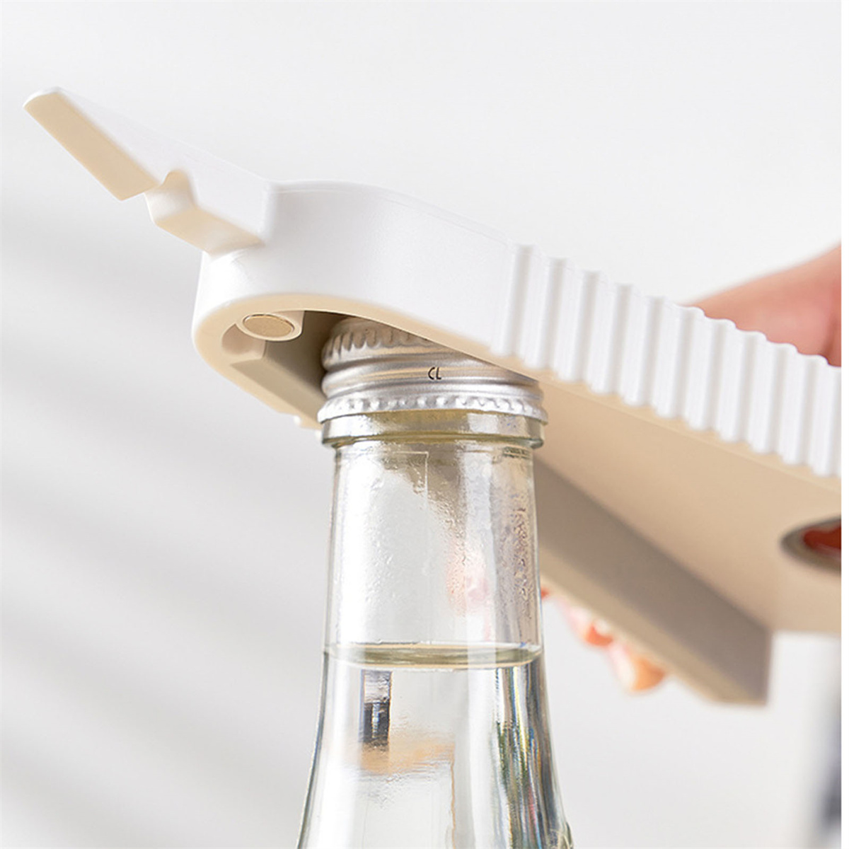 Weißer Flaschenöffner öffnet eine Flasche. Ein Teil der Hand einer Person ist sichtbar.
