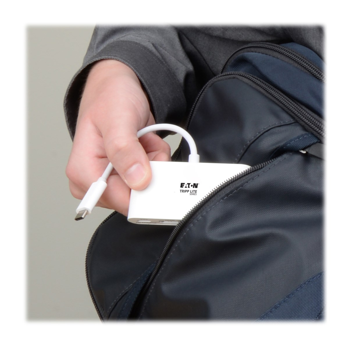 Una persona che mette un hub USB bianco in una borsa.
